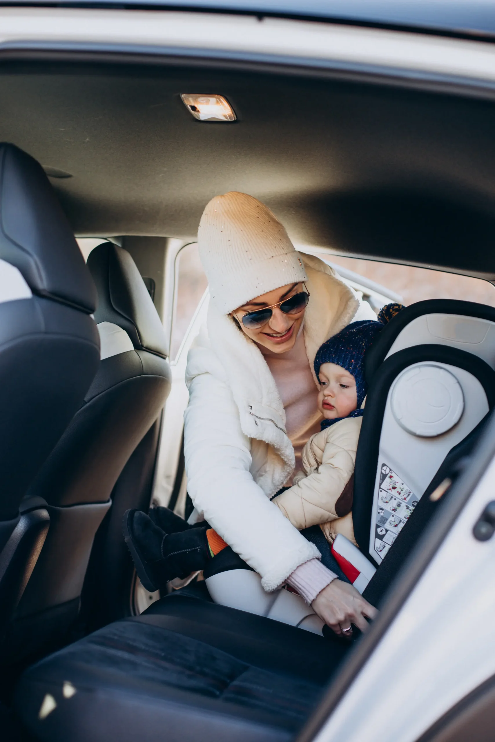 madre sujetando su hijo en el asiento del auto