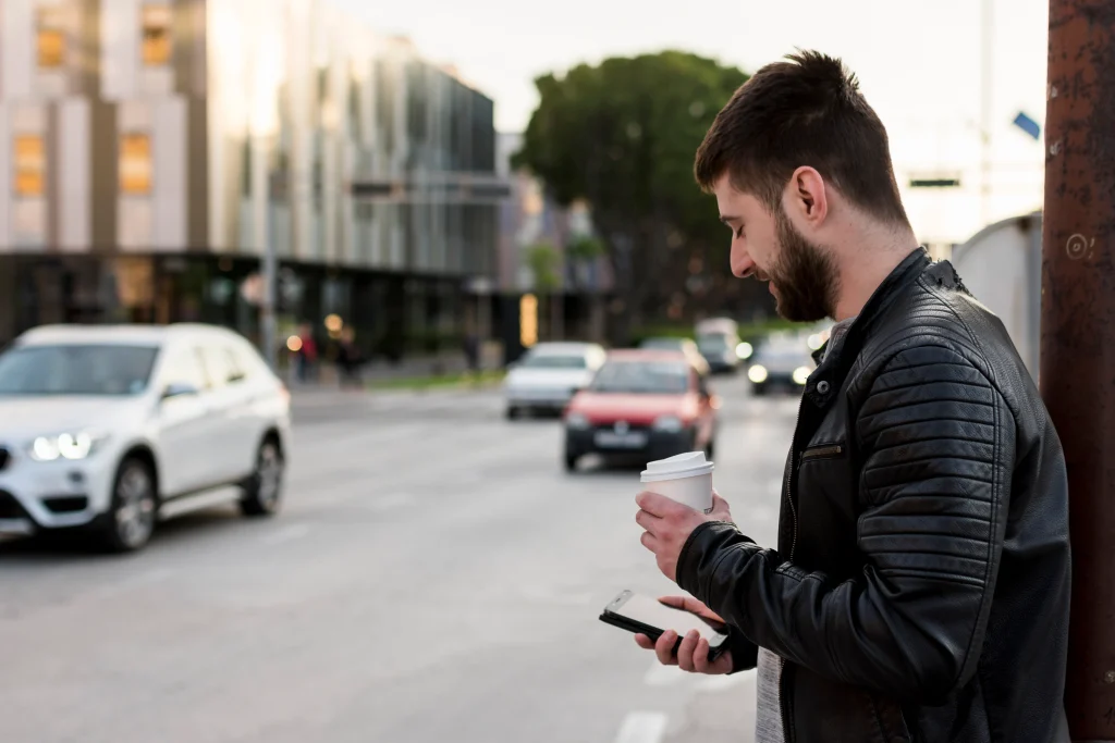 hombre adulto con cafe usando telefono movil