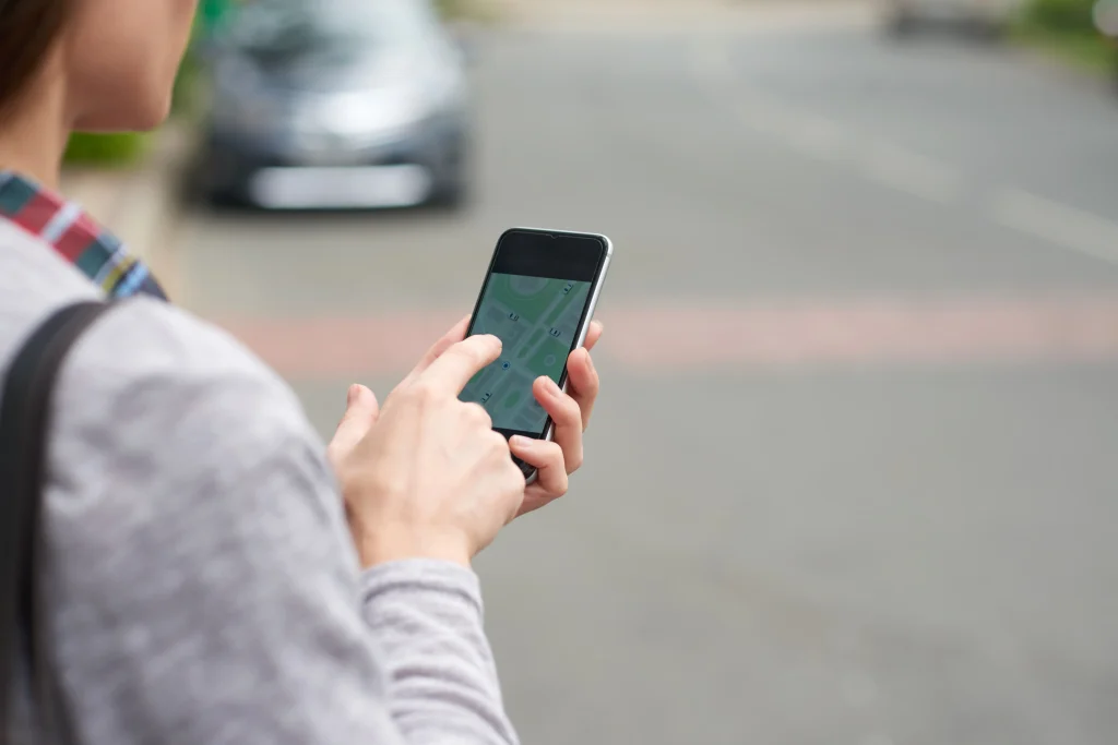 vista sobre el hombro de una persona irreconocible que sigue el taxi en la aplicacion movil
