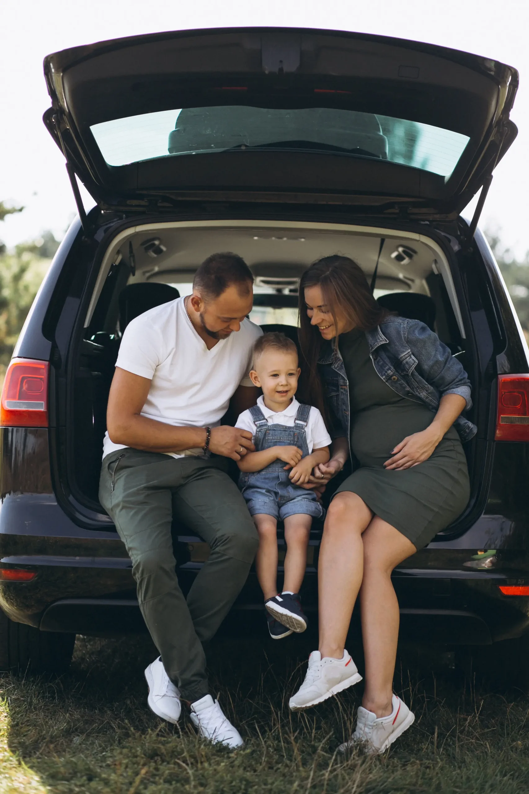 husband with pregnant wife their son sitting car