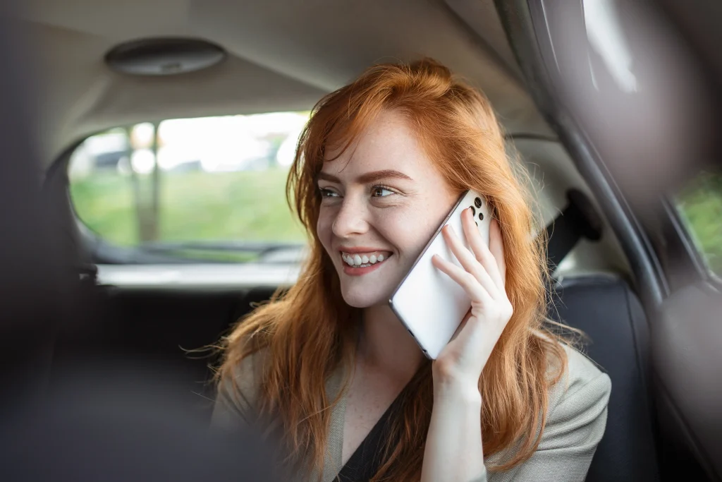 Estudiante hablando por teléfono en el interior de un taxi